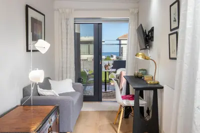 a living room with a table and a chair and a desk at House Indlovu in Hermanus