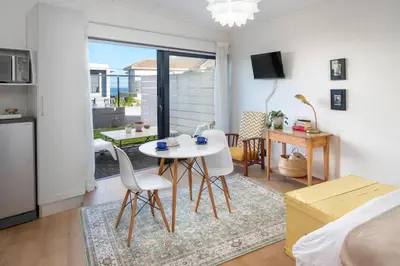 a kitchen and living room with a table and chairs at House Indlovu in Hermanus