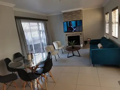 a living room with a blue couch and a table at Cosy 3 bedroom in Cape Town