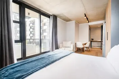 a bedroom with a bed and a large window at 404 Riverlands - Studio Apartment with Parking in Cape Town
