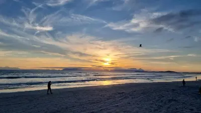 a group of people flying a kite on the beach at 3 On Herschell in Strand