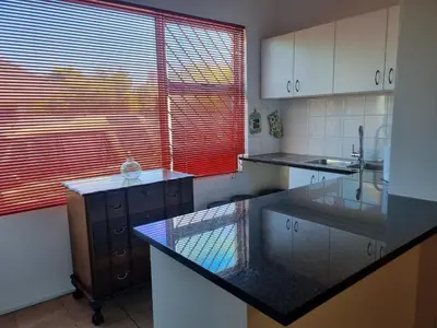 a kitchen with a black counter top and a window at 3 On Herschell in Strand