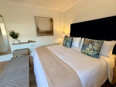a bedroom with a large white bed with pillows at The Ya Ya Apartment in Stellenbosch