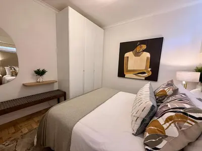 a bedroom with a bed and a painting on the wall at The Ya Ya Apartment in Stellenbosch