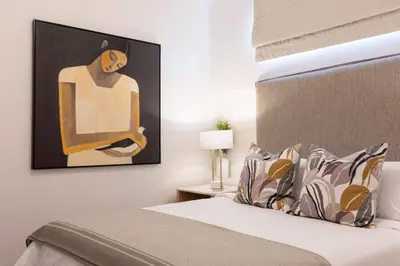 a bedroom with a bed with a painting on the wall at The Ya Ya Apartment in Stellenbosch