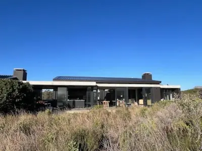 a house on the side of a hill at The Glass House Loft in Bettyʼs Bay