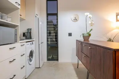 a kitchen with a refrigerator and a washing machine at The Glass House Loft in Bettyʼs Bay