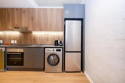 a kitchen with a washing machine and a sink at 504 Riverlands - Lux 2 Bedroom Apartment with Parking in Cape Town