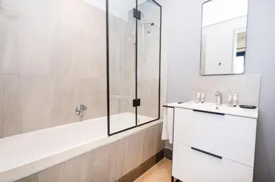 a white bathroom with a shower and a sink at 504 Riverlands - Lux 2 Bedroom Apartment with Parking in Cape Town
