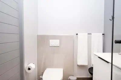 a white bathroom with a toilet and a shower at 504 Riverlands - Lux 2 Bedroom Apartment with Parking in Cape Town