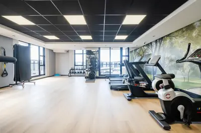 a gym with treadmills and exercise equipment and a mural at 504 Riverlands - Lux 2 Bedroom Apartment with Parking in Cape Town