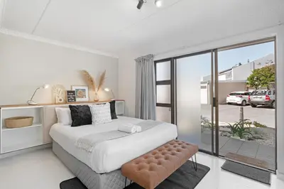 a bedroom with a large bed and a large window at San Norina Gardens 5 in Cape Town