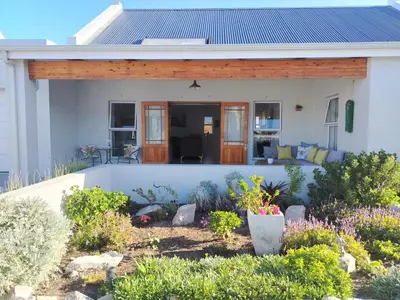 a house with a porch and a garden at Columbus Haven in Hermanus