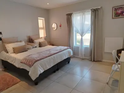 a bedroom with a large bed and a window at Columbus Haven in Hermanus