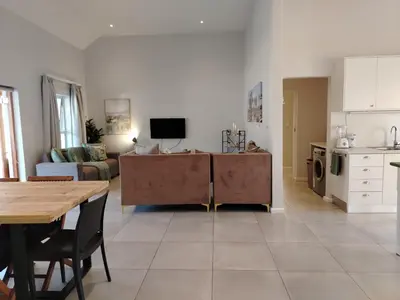 a kitchen and living room with a table and a couch at Columbus Haven in Hermanus