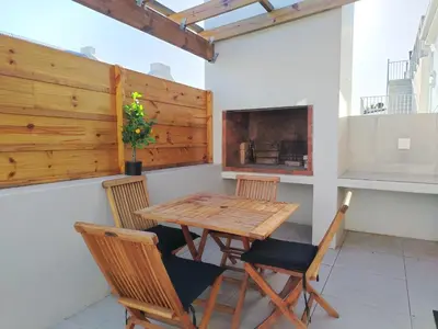 a table and chairs on a balcony with a fireplace at Columbus Haven in Hermanus