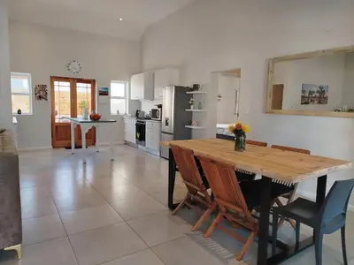 a large kitchen with a wooden table and chairs at Columbus Haven in Hermanus