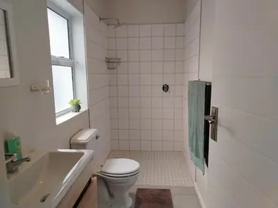 a white bathroom with a toilet and a sink at Columbus Haven in Hermanus