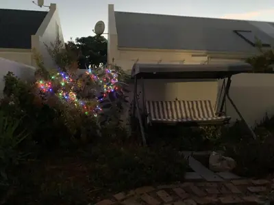 a bench in a garden with christmas lights at Columbus Haven in Hermanus