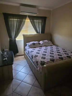 a bedroom with a bed and a window with curtains at Peters Place