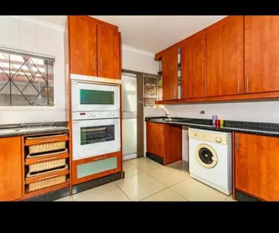 a kitchen with wooden cabinets and a white appliance at Peters Place