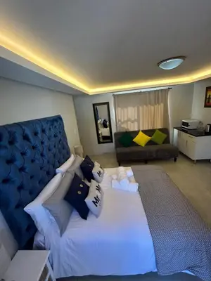 a bedroom with a large bed and a couch at Immaculate,Alttrative &Modern 6 minutes away from the beach in Cape Town