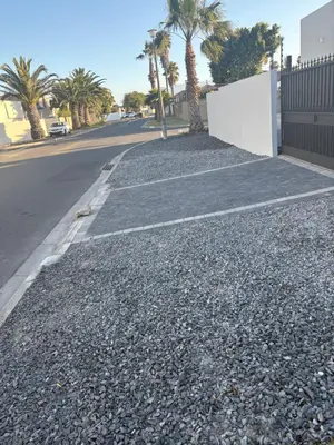 an empty street with palm trees and a fence at Immaculate,Alttrative &Modern 6 minutes away from the beach in Cape Town