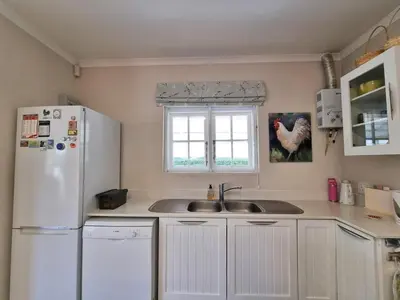 a kitchen with a white refrigerator and a sink at Moonlight in Hermanus