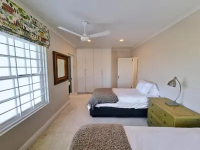 a bedroom with two beds and a window at Moonlight in Hermanus