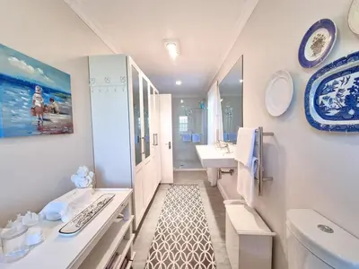 a bathroom with a sink and a toilet and a tub at Moonlight in Hermanus