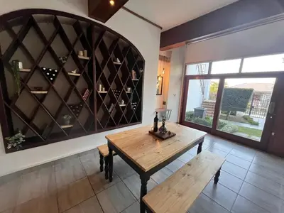 a dining room with a table and a wall of wine bottles at Durr's Nest - Central Paarl Mountain Retreat in Paarl