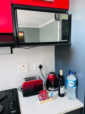 a kitchen counter with a toaster and a microwave at Entire Modern, Secure & Central Flat in Milnerton in Cape Town