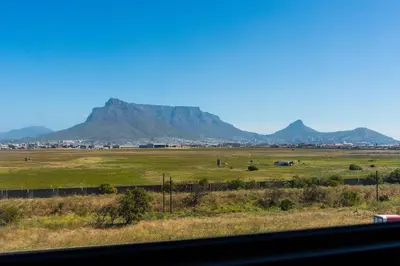 a view of a field with mountains in the background at 2 Bed Executive Apartment Table Mountain views in Cape Town