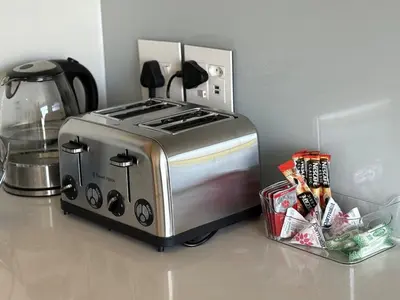 a toaster oven sitting on a counter next to a container at 2 Bed Executive Apartment Table Mountain views in Cape Town