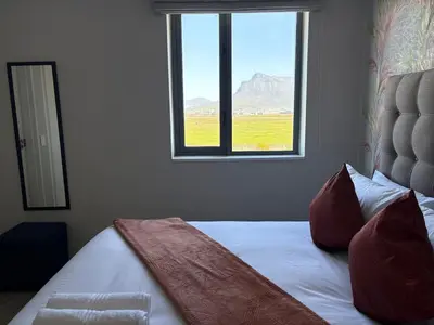 a bedroom with a bed with a view of a window at 2 Bed Executive Apartment Table Mountain views in Cape Town