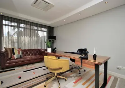 a living room with a desk and a couch at Cape Town Sunset Beach Luxury Beachfront Villa in Cape Town