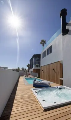 a hot tub on the deck of a house at Ocean 9 Beachfront Residence in Cape Town