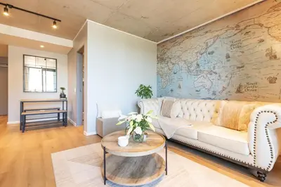 a living room with a white couch and a map wall at Riverlands, Observatory, Luxury 1 Bed with views in Cape Town