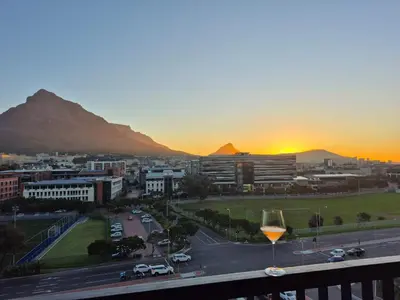 a glass of wine on a balcony with a city at Riverlands, Observatory, Luxury 1 Bed with views in Cape Town