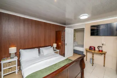 a bedroom with a large bed and a television at Self Contained 2 bed Room Condo in Parow
