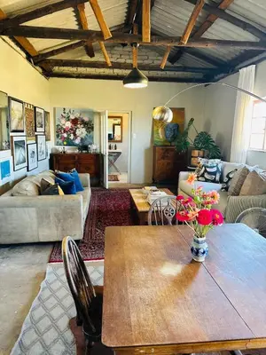 a living room with a table and a couch at The Old Dairy at Allemanskloof in Paarl
