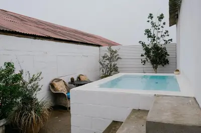 a large swimming pool in a white building with at The Old Dairy at Allemanskloof in Paarl