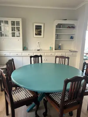 a dining room with a blue table and chairs at Sunset sea views - 4 bedroom home in Hermanus