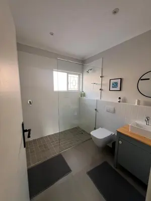 a bathroom with a shower and a toilet and a sink at Sunset sea views - 4 bedroom home in Hermanus