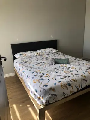 a bed with a comforter and pillows on it at Cape on Porterfield in Cape Town