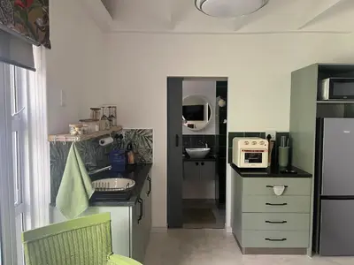a small kitchen with a sink and a microwave at carol close1 small apartment in Eversdal