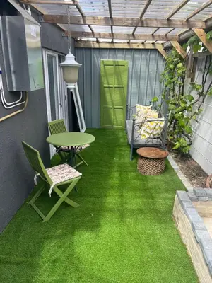 a patio with green grass and a table and chairs at carol close1 small apartment in Eversdal