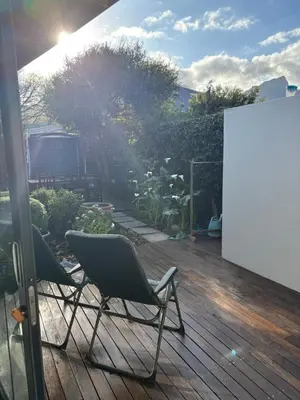 two chairs sitting on top of a wooden deck at The Modest Mansion in Cape Town