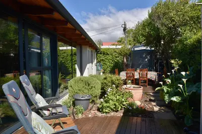 a patio with chairs and plants in a yard at The Modest Mansion in Cape Town