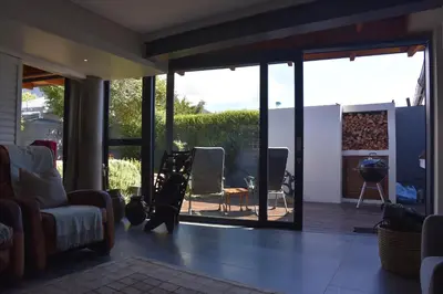 a living room with sliding glass doors and a patio at The Modest Mansion in Cape Town